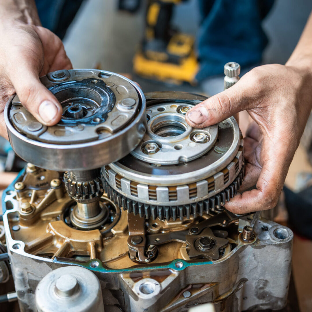 Motorcycle mechanic working on the repair of a motorcycle engine ,working at garage, maintenance, repair motorcycle concept